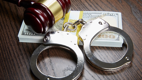 gavel, handcuffs and a stack of money